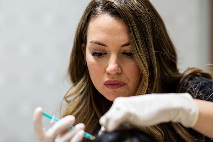 Kate injecting Botox to patient forehead