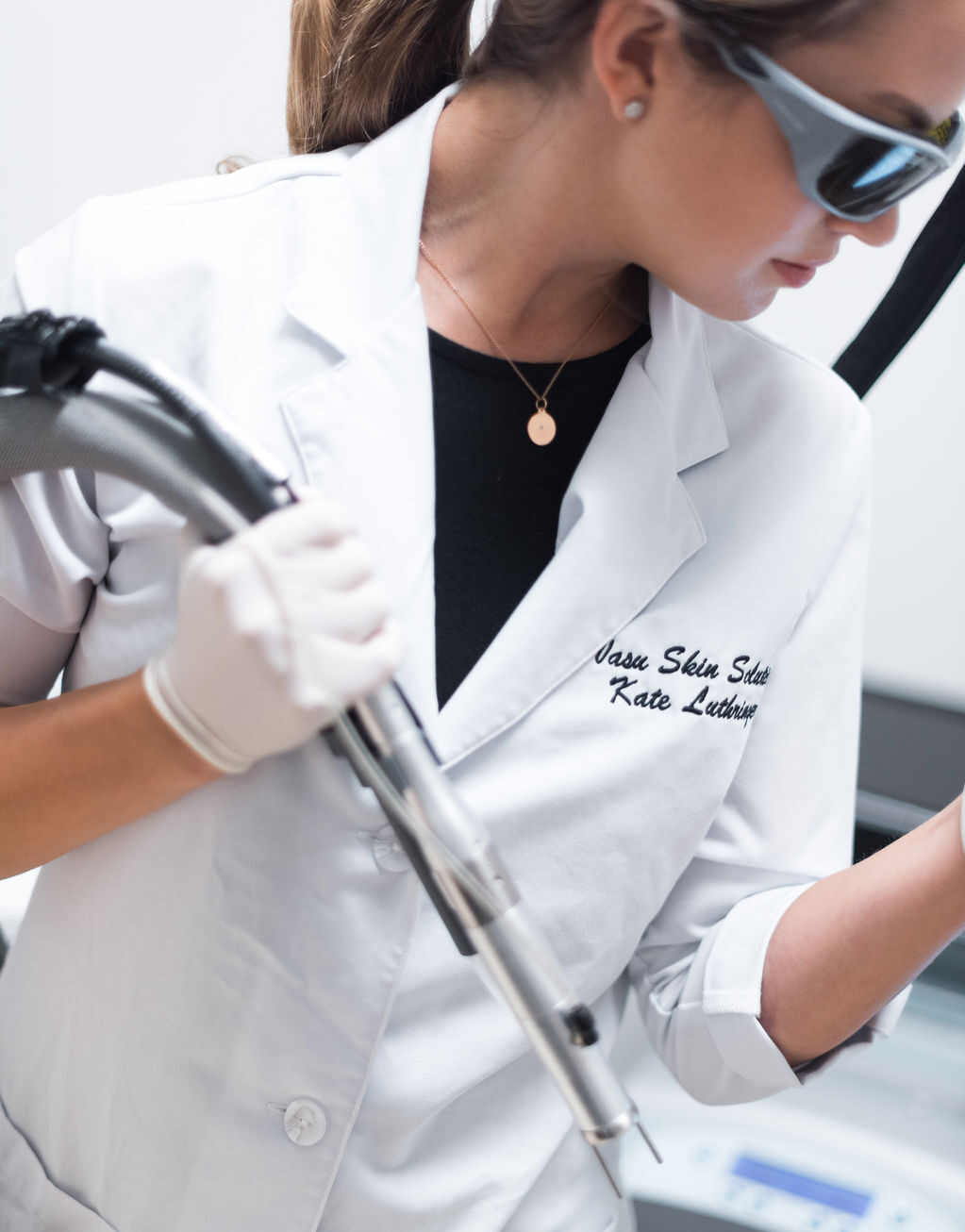 Kate in white coat holding laser for hair removal